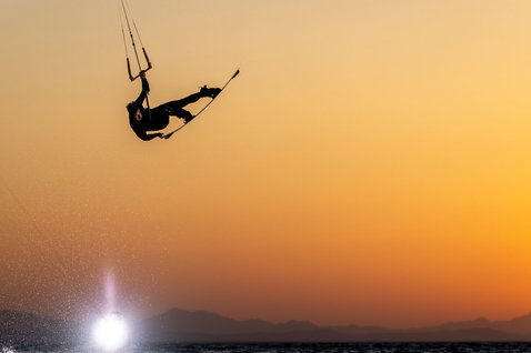Duotone TS Freestyle SLS twin-tip kiteboard en train de faire du kitesurf sur la plage avec montagnes
