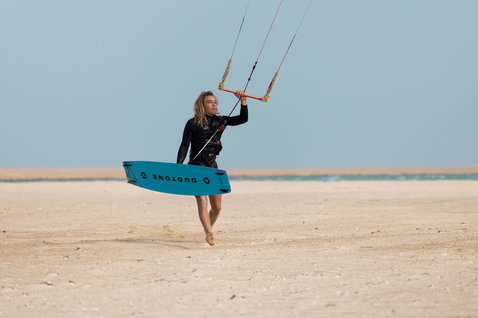 Duotone TS Big Air SLS kiteboard twin-tip lors du kitesurf dans un lagon de plage de sable