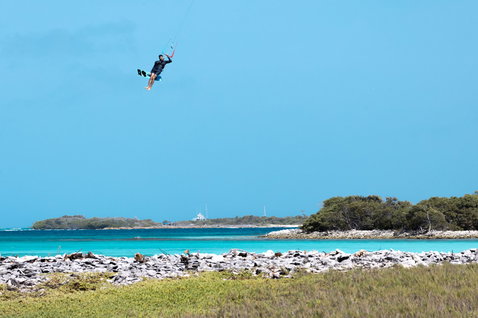 Duotone TS Big Air SLS twin-tip kiteboard en kitesurf dans un lagon tropical avec côte rocheuse, mangroves et eau des Caraïbes