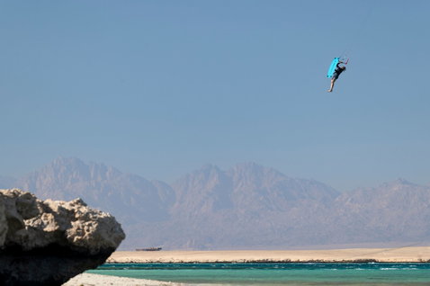 Duotone TS Big Air SLS twin-tip kiteboard en kitesurf sur une côte désertique avec lagon turquoise et chaîne de montagnes arides