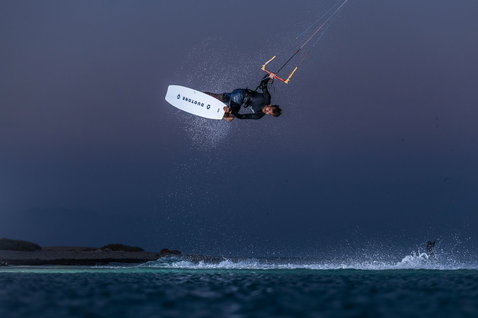 Duotone TS Park kiteboard twin-tip 151cm en train de faire du kitesurf sur la plage de l'océan