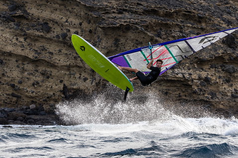 Duotone Eagle D/LAB 2026 planche de windsurf lors du surf de vagues sur une côte océanique rocheuse