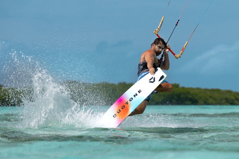Prancha twin-tip Duotone Select Concept Blue durante kitesurf em lagoa oceânica tropical