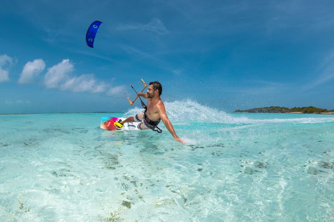 Prancha twin-tip Duotone Select Concept Blue durante kitesurf em lagoa tropical com águas turquesa rasas
