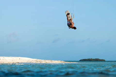 Duotone Jaime Concept Blue kiteboard twin-tip lors du kitesurf sur une plage tropicale avec île de sable blanc
