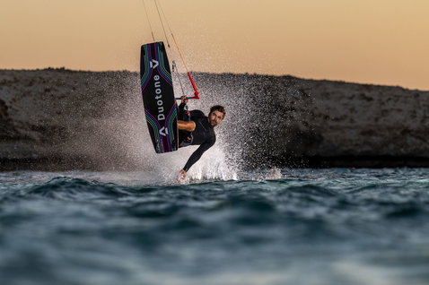 Duotone Jaime Concept Blue twin-tip kiteboard en train de faire du kitesurf sur un littoral rocheux