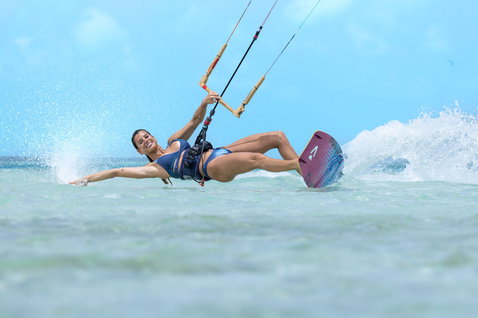 Duotone Soleil Concept Blue tabla de kitesurf twin-tip durante el kitesurf en una playa tropical de aguas planas