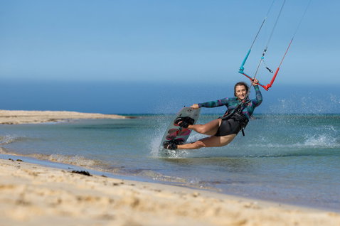 Duotone Soleil SLS Twin-Tip Kiteboard beim Kitesurfen am Strand mit flachem Wasser