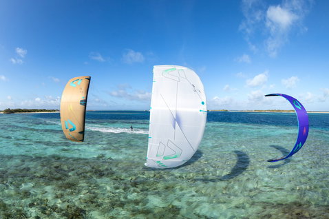 Duotone Rebel SLS LEI kite during kitesurfing over a tropical ocean lagoon with coral reef