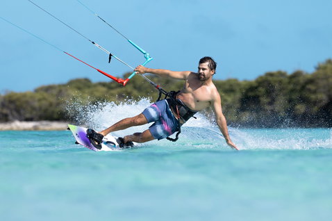 Duotone Select SLS Twin-Tip Kiteboard beim Kitesurfen in einer tropischen Lagune mit türkisblauem Flachwasser