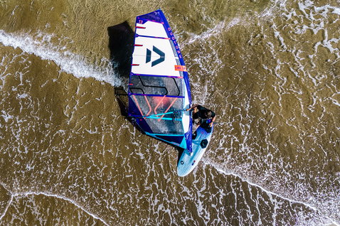 Duotone Falcon Fin SLS planche de windsurf en train de faire du windsurf sur la plage avec vagues