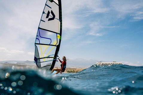Duotone E_Pace voile freeride lors de windsurf sur l'océan avec toile de fond montagneuse
