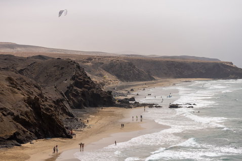 Duotone Evo SLS Concept Blue LEI kite haciendo kitesurf en una playa con acantilados rocosos