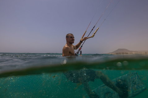 Duotone Evo SLS Concept Blue LEI kite haciendo kitesurf en el océano con costa montañosa