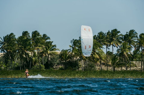 Duotone Evo SLS LEI kite during kitesurfing in a tropical lagoon with palm trees