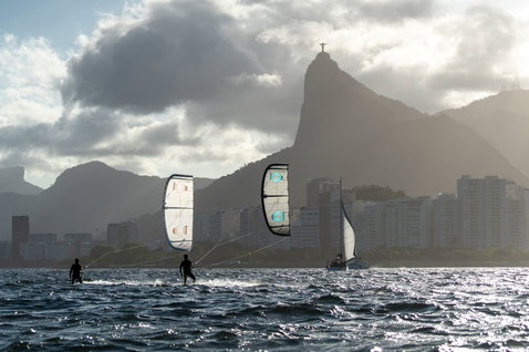 Duotone Evo SLS LEI kite during kitesurfing in an ocean bay with urban coastline and mountains
