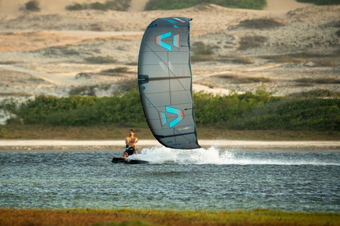 Duotone Evo SLS LEI kite during kitesurfing at a coastal lagoon with sand dunes