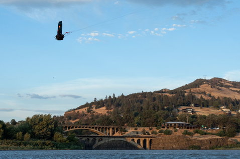 Duotone Rebel D/LAB LEI kite durante il kitesurf su un fiume con ponte e montagne a Hood River, Oregon