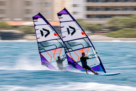 Duotone S_Pace Freeride-Segel beim Windsurfen an der Ozeanküste mit urbanem Hintergrund