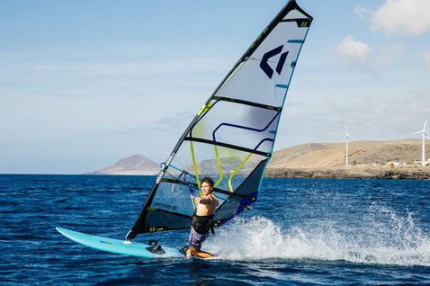 Duotone Eagle SLS planche de windsurf lors du windsurf en océan ouvert avec côte volcanique et éoliennes
