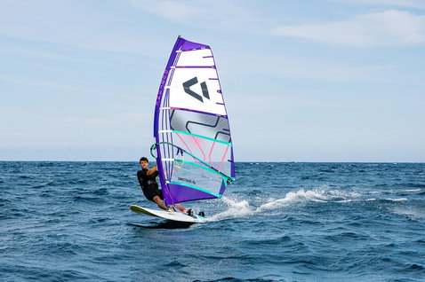Duotone X Pace crossover sail during windsurfing on the open ocean in deep navy blue, purple and teal