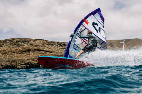 Planche de windsurf Duotone Blitz SLS lors du surf de vagues sur une côte volcanique rocheuse