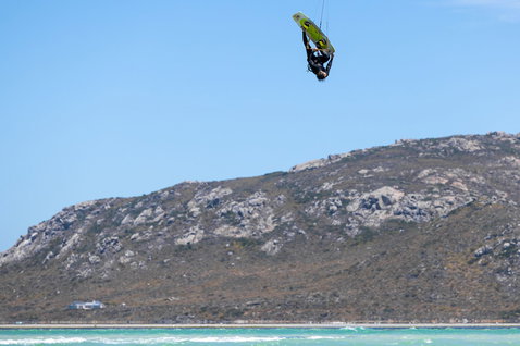 Twin-tip kiteboard lors du kitesurf dans un lagon côtier avec montagnes rocheuses