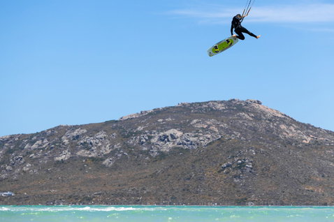 Gonzales kiteboard twin-tip en train de faire du kitesurf dans un lagon côtier avec montagnes rocheuses