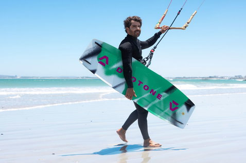 Duotone Spike twin-tip kiteboard lors d'une session de kitesurf sur une plage océanique