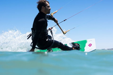 Duotone Spike planche de kitesurf twin-tip pendant le kitesurf dans l'océan aux eaux turquoise peu profondes