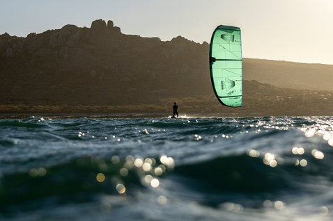 Duotone Evo LEI kite durante il kitesurf sulla costa oceanica con promontorio roccioso