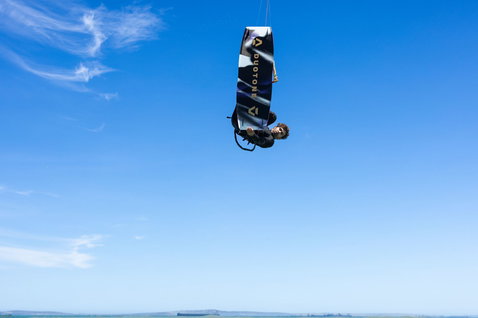 Duotone Spike SLS twin-tip kiteboard lors d'une session de kitesurf sur une côte océanique