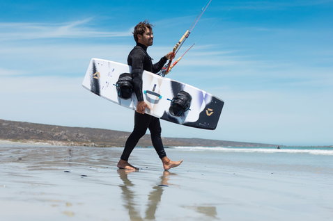 Duotone Spike SLS kiteboard pendant le kitesurf sur une plage océanique