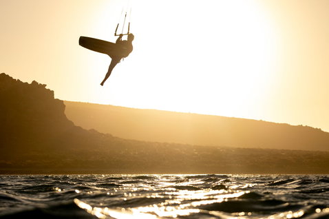 LEI kite during kitesurfing at the ocean coastline with rocky cliffs
