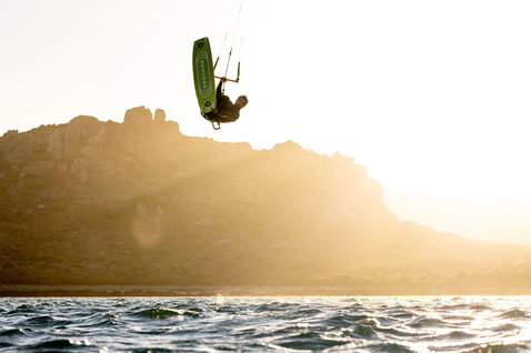LEI kite in lime green during kitesurfing at coastal ocean with rocky cliffs