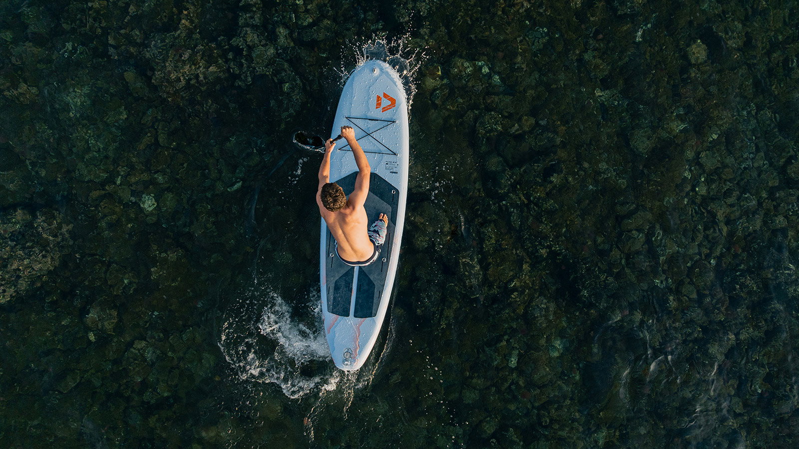 Duotone Flow Air SLS inflatable SUP board during stand-up paddleboarding on the ocean, aerial view