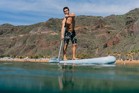 Stand up paddle gonflable Duotone Flow Air SLS lors d'une session de SUP dans une baie côtière calme