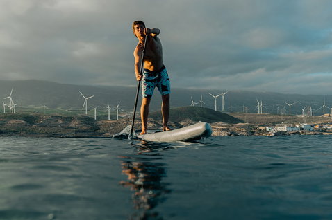 Duotone Raven Air SLS planche SUP gonflable lors d'une randonnée en mer avec parc éolien côtier en arrière-plan