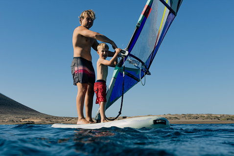 Tavola iSUP Duotone Alfa WS Air durante il windsurf in mare con adulto e bambino