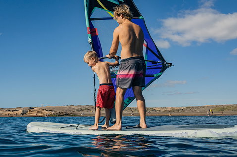 Tavola gonfiabile Duotone iSUP Alfa WS Air durante il windsurf su acque piatte con adulto e bambino