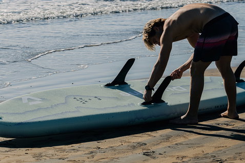 Duotone Alfa WS Air iSUP Windsurfboard beim Aufbau am Strand mit Mastadapter