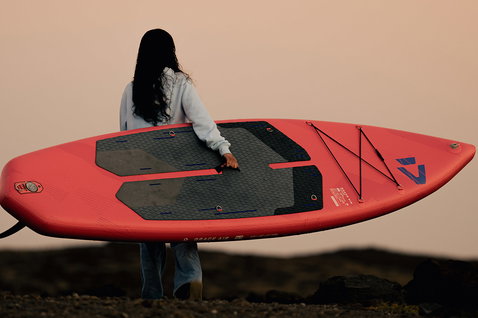 Duotone Grace Air SLS iSUP package 11'2 in coral during stand-up paddleboarding at the coast at dusk