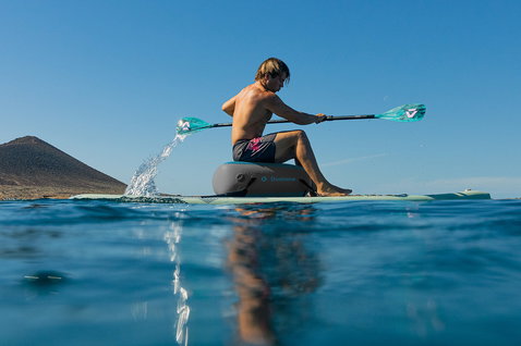Duotone Blitz Air SLS iSUP Package during kayak SUP touring on the ocean with volcanic coastline backdrop