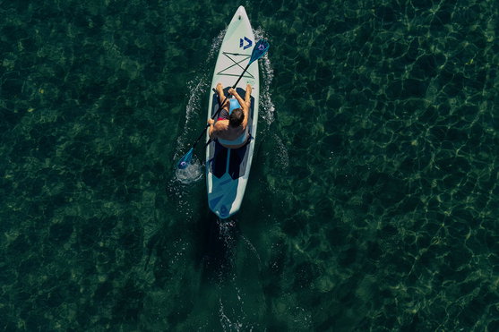 Duotone Blitz Air SLS SUP insuflável em configuração caiaque a remar em água turquesa cristalina