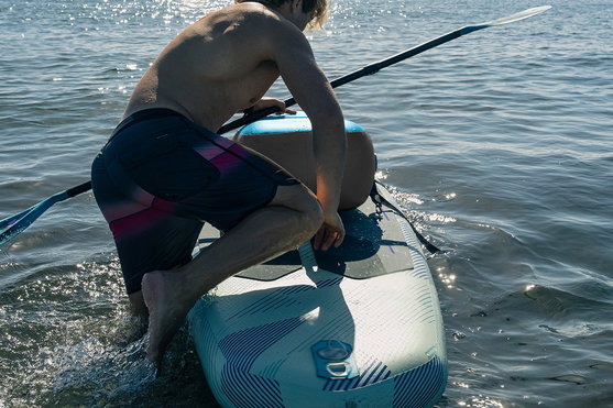 Duotone Blitz Air SLS iSUP durante remada de caiaque em águas calmas num dia ensolarado