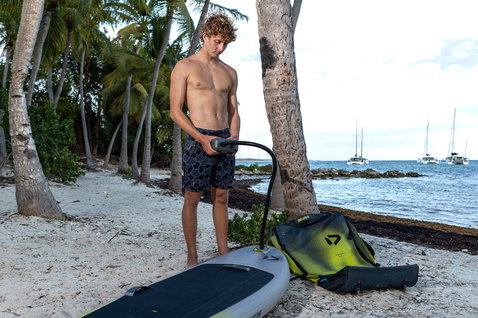 Tavola da foil gonfiabile Duotone Midfish Air gonfiata su spiaggia tropicale con borsa da viaggio