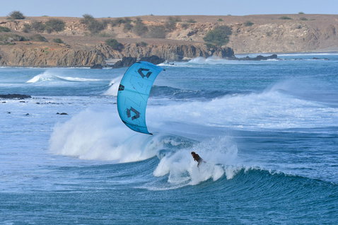 D/LAB LEI kite during wave riding at an ocean coast with rocky shoreline