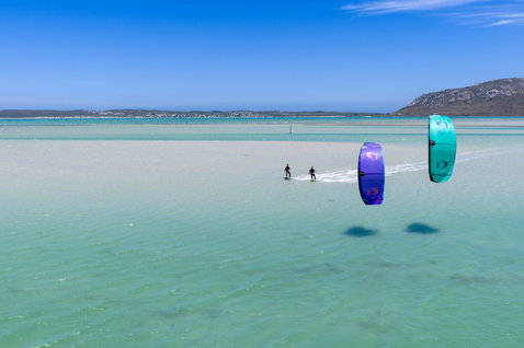 Duotone Evo LEI Kite beim Kitesurfen in einer türkisblauen Lagune mit zwei Fahrern