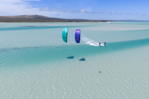 Duotone Evo LEI Kite beim Kitesurfen über türkisfarbenem Flachwasser, Drohnenaufnahme