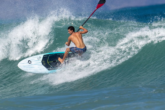 Duotone Cosmic SLS SUP wave hardboard during wave surfing in the ocean in teal and white